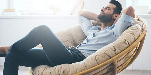 Mann entstannt sich in einem gemütlichen Stuhl